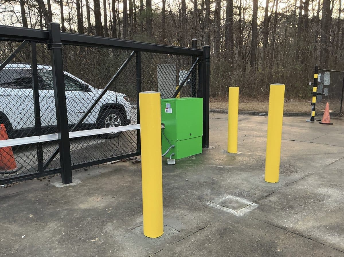 Black chain link swing gate with operator and bollards in Georgia
