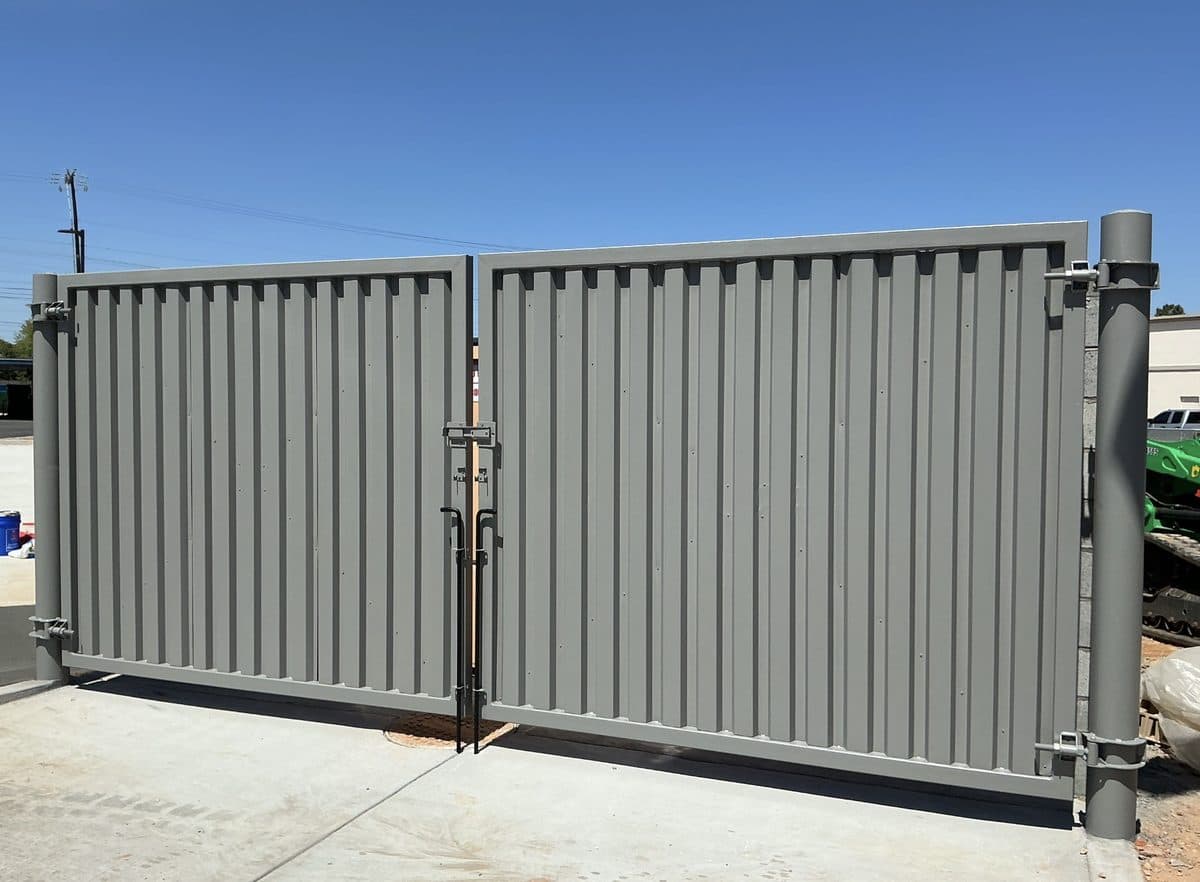 Steel panel dumpster gate with bollards protecting hinges in Georgia